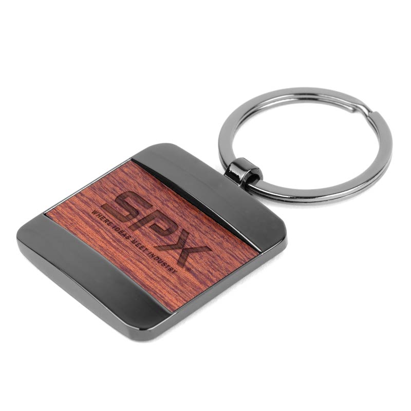 Bolton Square Wood Key Chain - This contemporary accessory blends gunmetal-plated metal with a rectangular wooden centerpiece, creating a statement piece that's both modern and earthy. Metal is a zinc alloy with gunmetal plating and a rectangular design. Key chain features a rosewood in a clear finish. 35mm split ring also with gunmetal plating. Gift box included for a stylish presentation.